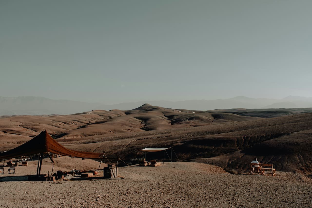 Les collines de pierre nue du désert d’Agafay, le Haut Atlas à l’horizon